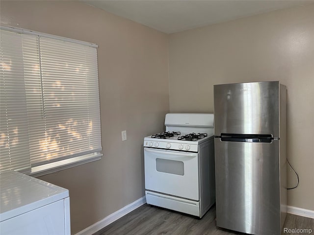 11236 Studebaker Ave, Warren, MI 48089 - kitchen featuring freestanding refrigerator, white gas range oven, washer / dryer, and wood finished floors