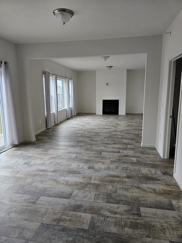 8781 Prairie Stone Dr SW, Byron Center, MI 49315 - unfurnished living room featuring wood finished floors and a fireplace