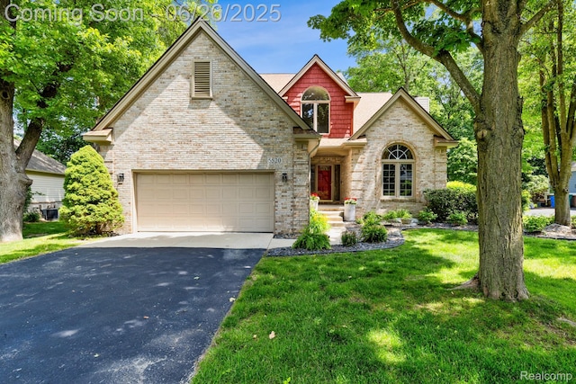5520 Huron Hills Dr, Commerce Twp, MI 48382 - view of front of house with asphalt driveway, an attached garage, brick siding, and a front yard