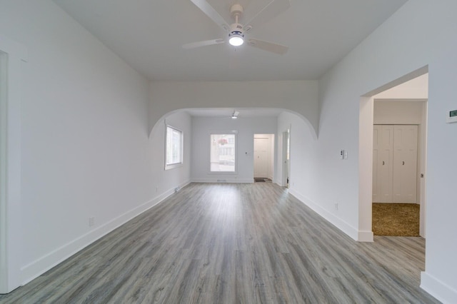 28 E Southern Ave, Muskegon, MI 49442 - unfurnished living room featuring a ceiling fan, arched walkways, and wood finished floors