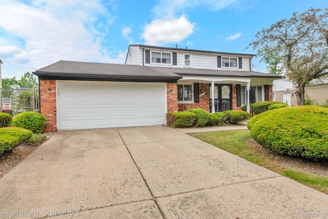 23719 Wendy Ln, Southfield, MI 48075 - view of front of property featuring brick siding, concrete driveway, an attached garage, and a porch
