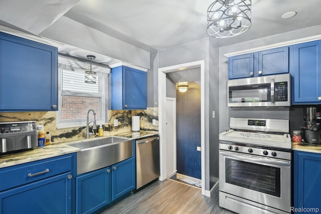 1333 N Franklin St, Dearborn, MI 48128 - kitchen featuring stainless steel appliances, blue cabinets, light wood-style floors, and tasteful backsplash