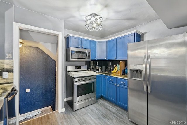 1333 N Franklin St, Dearborn, MI 48128 - kitchen featuring appliances with stainless steel finishes, blue cabinets, light wood-style floors, a chandelier, and light countertops