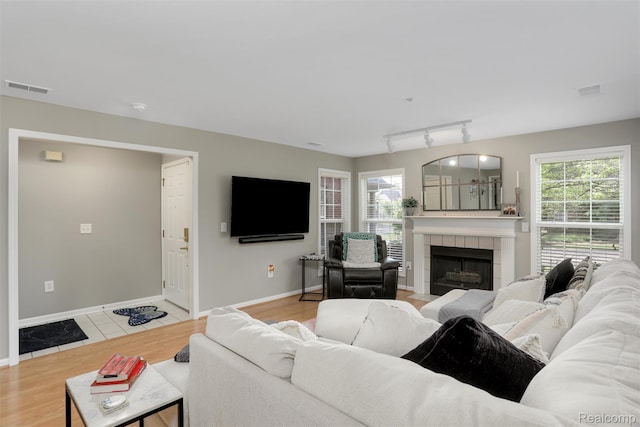 28185 Carlton Way Dr, Novi, MI 48377 - living room featuring a tiled fireplace, track lighting, and light wood finished floors