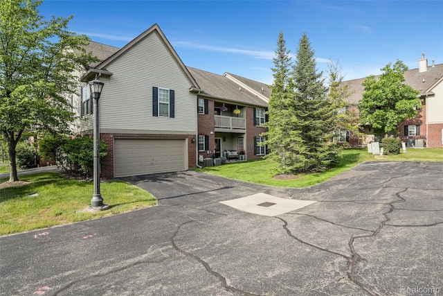 28185 Carlton Way Dr, Novi, MI 48377 - view of front of house with brick siding, asphalt driveway, a front yard, a garage, and a balcony