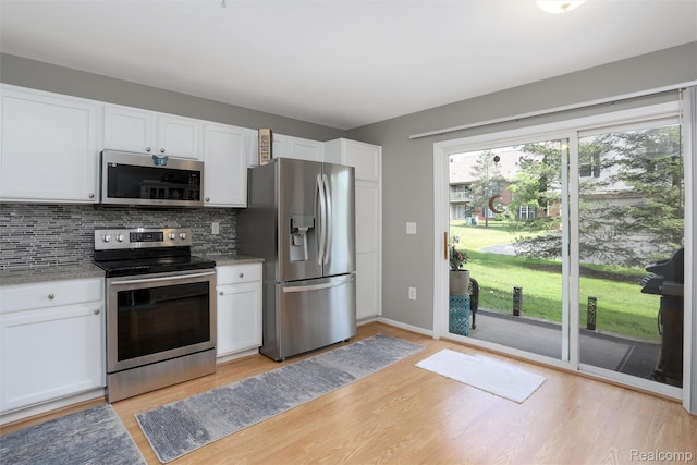 28185 Carlton Way Dr, Novi, MI 48377 - kitchen featuring stainless steel appliances, healthy amount of natural light, light wood finished floors, and tasteful backsplash