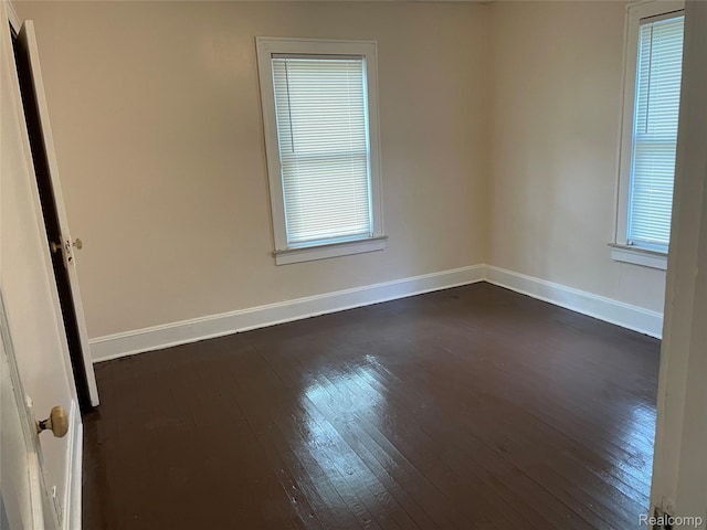 747 Vermilya Ave, Flint, MI 48507 - empty room with dark wood-style floors and healthy amount of natural light