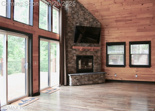 3199 N Loop Ct, Middleville, MI 49333 - unfurnished living room with lofted ceiling, wood finished floors, wooden walls, a stone fireplace, and wood ceiling