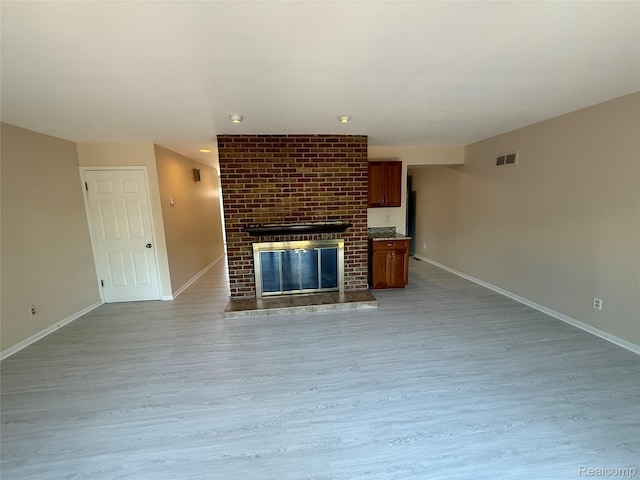6352 Laurentian Ct, Flint, MI 48532 - unfurnished living room with wood finished floors and a fireplace