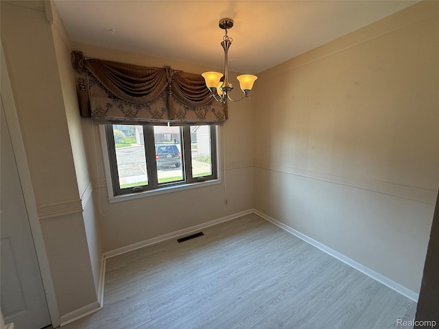 6352 Laurentian Ct, Flint, MI 48532 - spare room featuring a chandelier and wood finished floors