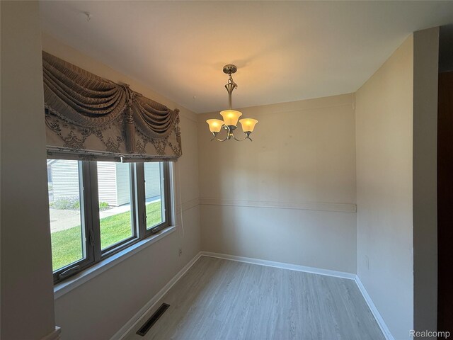 6352 Laurentian Ct, Flint, MI 48532 - spare room with a chandelier and light wood-type flooring