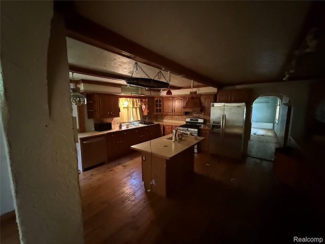 6456 W Court St, Flint, MI 48532 - kitchen featuring appliances with stainless steel finishes, a center island with sink, glass insert cabinets, arched walkways, and dark wood-style floors