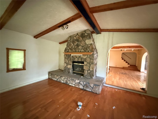 6456 W Court St, Flint, MI 48532 - unfurnished living room with arched walkways, a stone fireplace, and wood finished floors