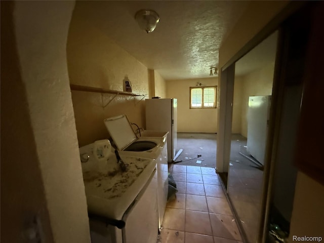 6456 W Court St, Flint, MI 48532 - laundry area with a textured ceiling, washing machine and clothes dryer, and light tile patterned flooring