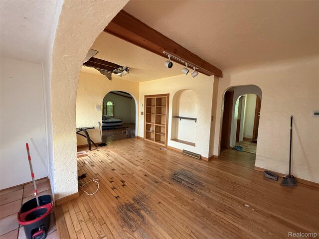 6456 W Court St, Flint, MI 48532 - spare room featuring arched walkways, hardwood / wood-style floors, rail lighting, and a textured wall