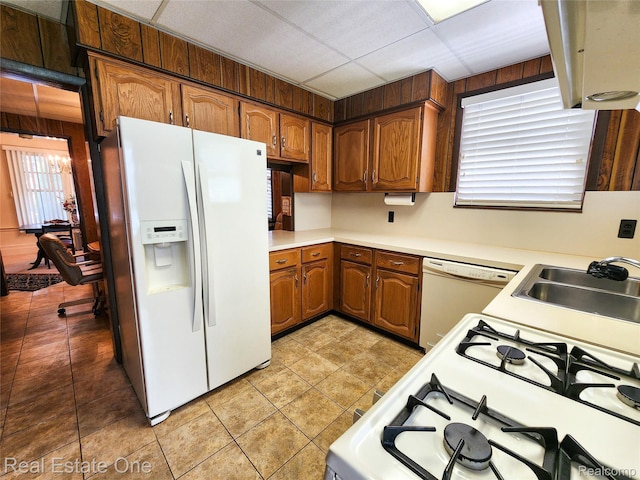 118 Massachusetts St, Highland Park, MI 48203 - kitchen featuring white appliances, light countertops, light tile patterned floors, and brown cabinetry