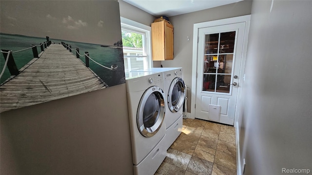 3900 Hillcrest, Highland, MI 48356 - laundry area featuring cabinet space, washing machine and clothes dryer, and light stone finish flooring