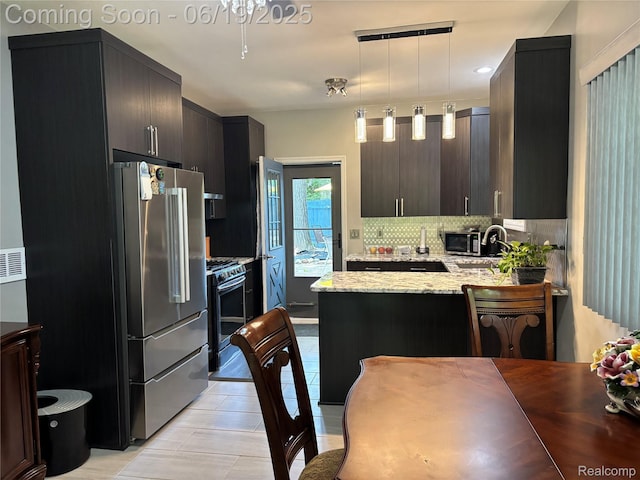 4817 Hickory Dr, Highland, MI 48356 - kitchen featuring stainless steel appliances, backsplash, a peninsula, light stone countertops, and pendant lighting