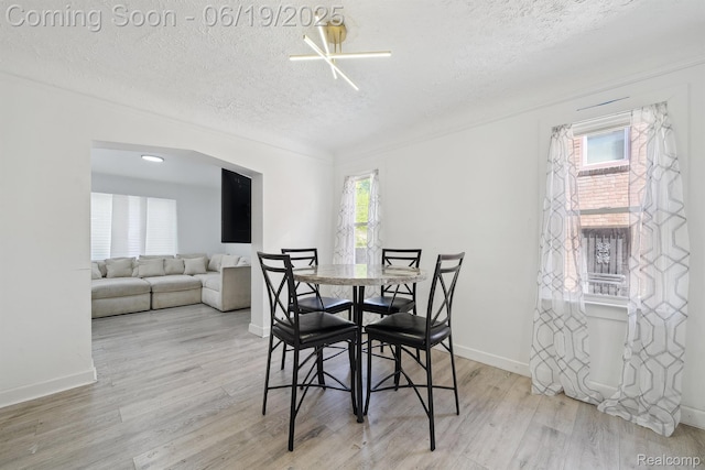 15477 Lauder St, Detroit, MI 48227 - dining area featuring a textured ceiling, wood finished floors, and arched walkways