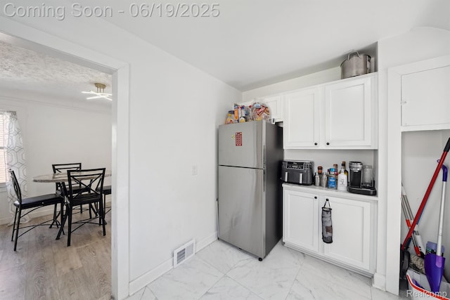15477 Lauder St, Detroit, MI 48227 - kitchen with freestanding refrigerator, white cabinetry, and light marble finish floors