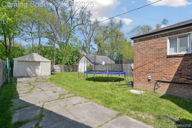 15477 Lauder St, Detroit, MI 48227 - view of yard featuring a trampoline, an outdoor structure, concrete driveway, and a garage