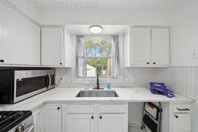 15477 Lauder St, Detroit, MI 48227 - kitchen with appliances with stainless steel finishes, white cabinetry, backsplash, and light stone counters