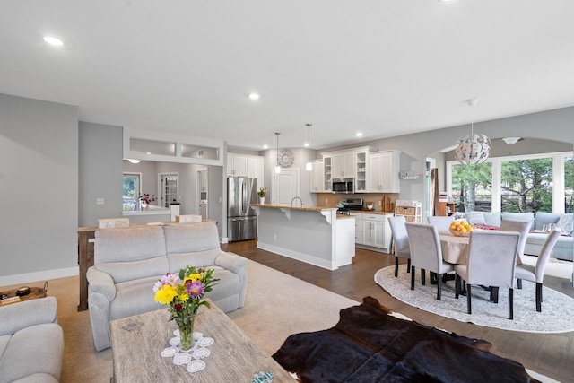 855 Cooks Crossing Dr SE, Byron Center, MI 49315 - living room featuring arched walkways, dark wood-type flooring, recessed lighting, and a chandelier