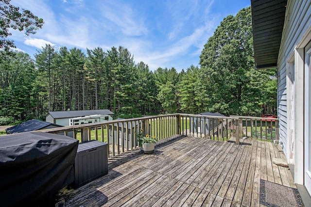 8041 Donovan Rd, Dexter, MI 48130 - deck with grilling area, a view of trees, and a storage unit