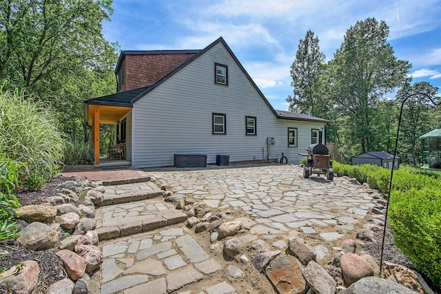 8041 Donovan Rd, Dexter, MI 48130 - rear view of house with a patio area and roof with shingles