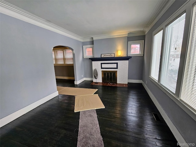 12645 Cloverlawn St, Detroit, MI 48238 - unfurnished living room featuring arched walkways, dark wood-type flooring, crown molding, and a brick fireplace