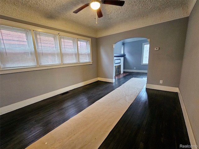 12645 Cloverlawn St, Detroit, MI 48238 - spare room featuring arched walkways, ceiling fan, dark wood finished floors, a textured ceiling, and a fireplace