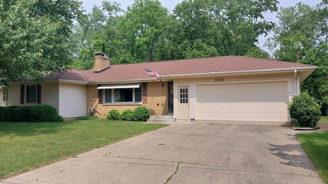 5037 Old Colony Rd, Portage, MI 49024 - single story home with an attached garage, concrete driveway, a front lawn, and a chimney
