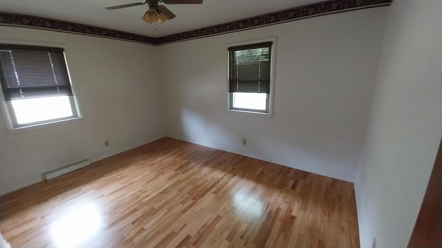 5037 Old Colony Rd, Portage, MI 49024 - unfurnished room featuring a baseboard heating unit, healthy amount of natural light, ceiling fan, and wood finished floors