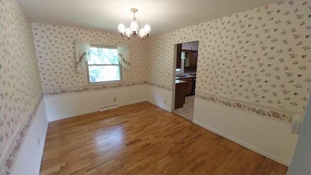 5037 Old Colony Rd, Portage, MI 49024 - empty room with a chandelier, wallpapered walls, and light wood-style flooring