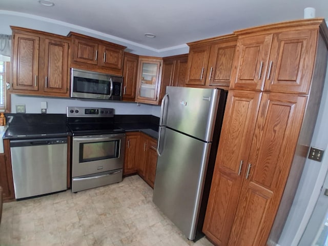 5397 E 80th St, Newaygo, MI 49337 - kitchen with stainless steel appliances, brown cabinetry, dark countertops, and glass insert cabinets