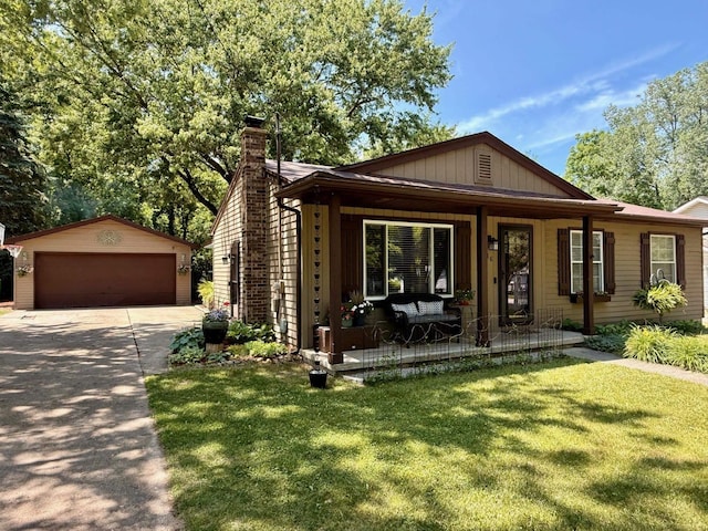 316 Colfax St, Fenton, MI 48430 - view of front of home with covered porch, an outbuilding, a garage, and a front yard