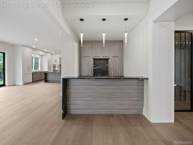 1120 Lyonhurst St, Birmingham, MI 48009 - kitchen featuring light wood-style floors, dark countertops, decorative light fixtures, a peninsula, and recessed lighting