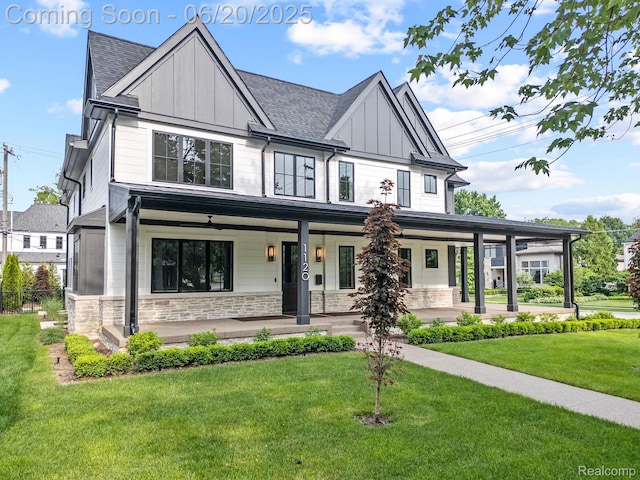1120 Lyonhurst St, Birmingham, MI 48009 - view of front of home featuring board and batten siding, covered porch, stone siding, a front yard, and a shingled roof