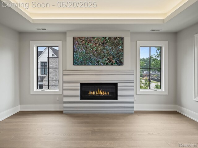 1120 Lyonhurst St, Birmingham, MI 48009 - unfurnished living room with a tray ceiling, wood finished floors, and a glass covered fireplace