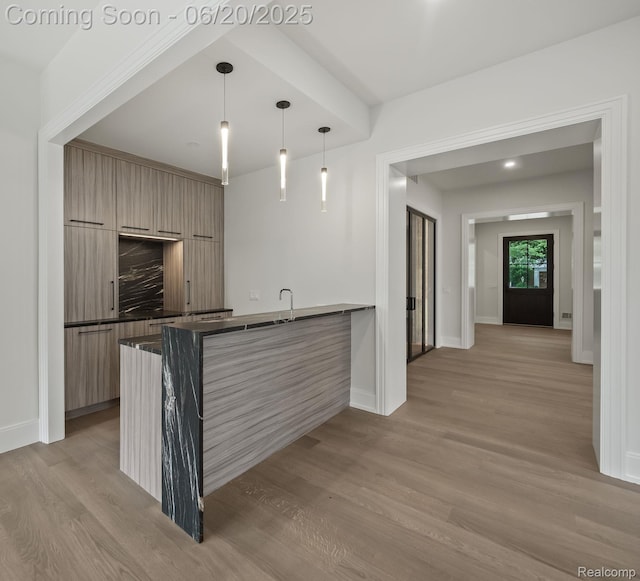 1120 Lyonhurst St, Birmingham, MI 48009 - kitchen featuring modern cabinets, dark countertops, light wood-style flooring, and a peninsula