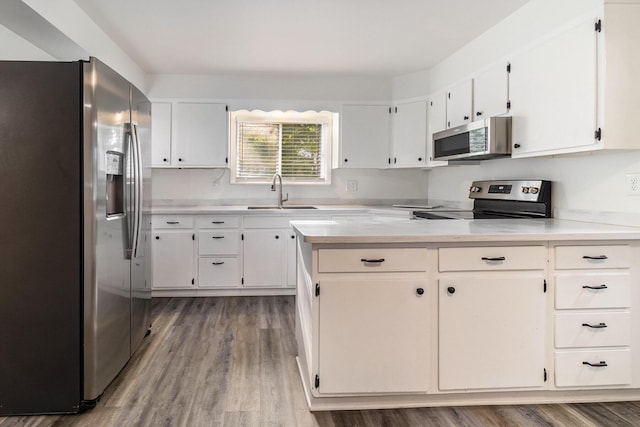 922 Marion Ave, Big Rapids, MI 49307 - kitchen with appliances with stainless steel finishes, wood finished floors, light countertops, and white cabinetry