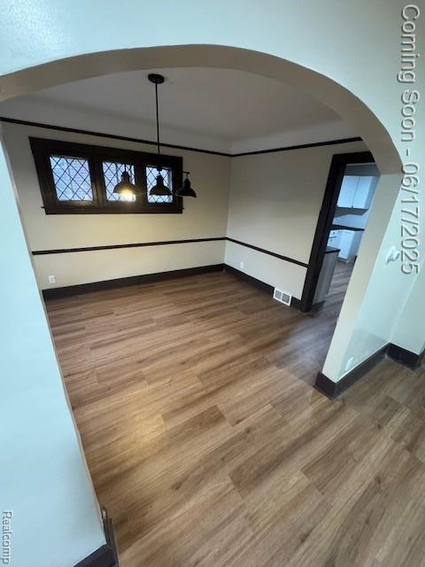 5215 Buckingham Ave, Detroit, MI 48224 - unfurnished dining area featuring arched walkways and wood finished floors