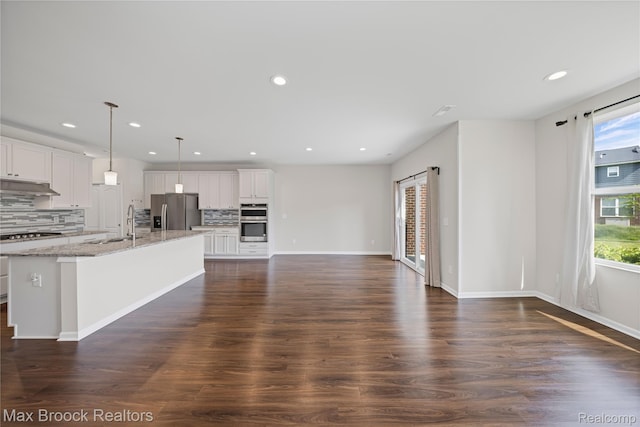 43629 Prospect Unit 102, Novi, MI 48375 - kitchen with appliances with stainless steel finishes, tasteful backsplash, under cabinet range hood, light stone counters, and recessed lighting