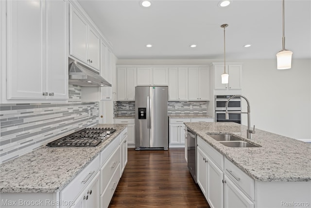 43629 Prospect Unit 102, Novi, MI 48375 - kitchen with stainless steel appliances, under cabinet range hood, white cabinetry, backsplash, and a center island with sink