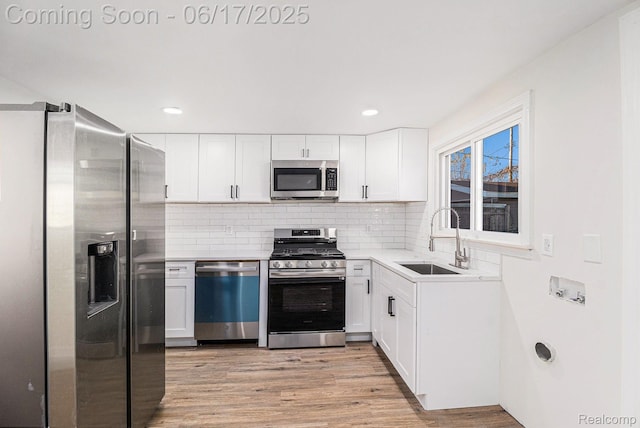 408 W Jarvis Ave, Hazel Park, MI 48030 - kitchen featuring stainless steel appliances, light wood-style floors, decorative backsplash, white cabinetry, and recessed lighting