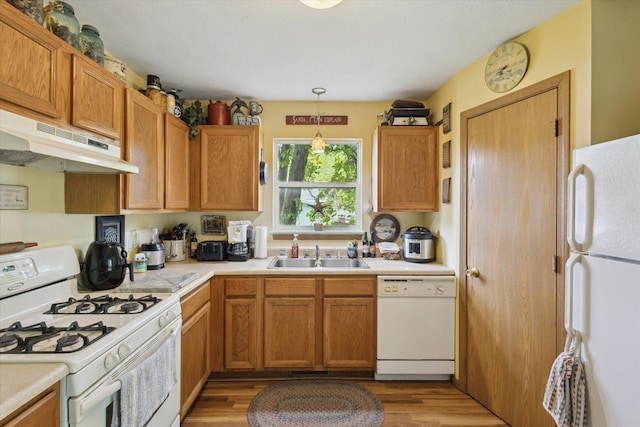 857 Kalamazoo St, South Haven, MI 49090 - kitchen featuring white appliances, under cabinet range hood, light countertops, light wood-style flooring, and hanging light fixtures
