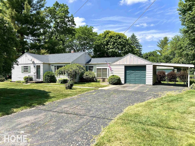 435 Brandon St, Owosso, MI 48867 - ranch-style home featuring board and batten siding, asphalt driveway, an attached garage, and a front lawn