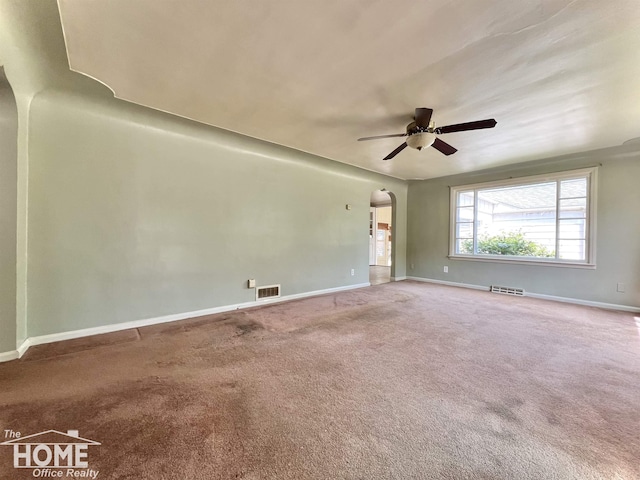 435 Brandon St, Owosso, MI 48867 - unfurnished room featuring arched walkways, ceiling fan, and carpet
