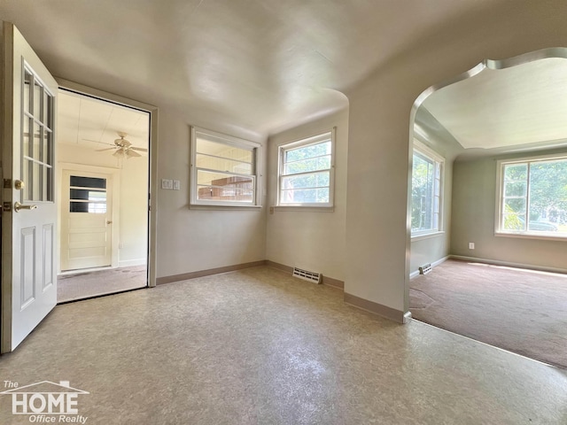 435 Brandon St, Owosso, MI 48867 - spare room featuring plenty of natural light, a ceiling fan, and arched walkways