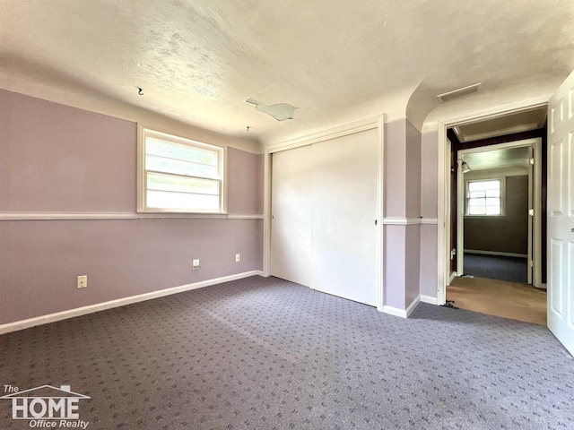 435 Brandon St, Owosso, MI 48867 - unfurnished bedroom with carpet floors, a textured ceiling, and a closet